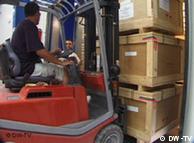 Gabelstapler transportiert drei Kisten (Foto: DW-TV)